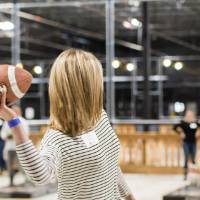 An alumna about to throw a football at the Fowling Fun Event